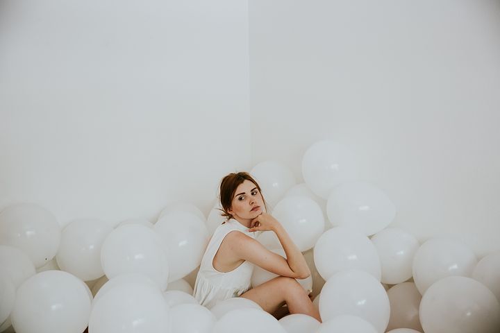 woman surrounded by white balloons